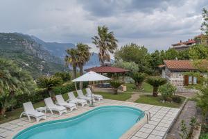 圣安吉洛Villa La Pace的一个带白色椅子和遮阳伞的游泳池