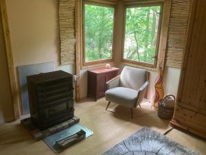 a living room with a stove and a chair at Bungalow Biberspur in Zieko