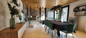 een eetkamer met een tafel en groene stoelen bij Sea-renity 23 met sauna en jacuzzi in Eggewaartskapelle