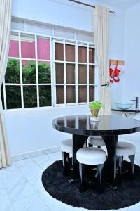 a dining room with a black table and chairs at Cheerful 3-Bedroom Home in a Family Setting in Kira