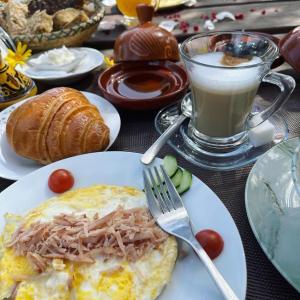 une assiette de nourriture avec une omelette et une tasse de café dans l'établissement Equi Palace & SPA Near Aeroport, à Berrechid