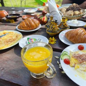 - une table avec des assiettes de nourriture et une tasse de jus d'orange dans l'établissement Equi Palace & SPA Near Aeroport, à Berrechid
