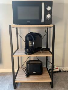 a microwave on top of a shelf with a radio at Ferienwohnung Sunny - Moderne Ferienwohnung im Grünen in Saarbrücken-West in Saarbrücken