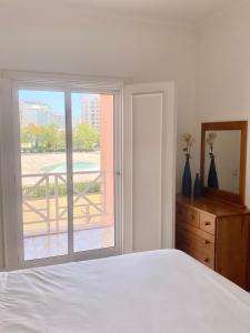 een slaapkamer met een bed en uitzicht op een balkon bij Vilamoura City Center Flat in Vilamoura