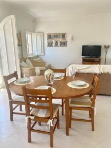 una mesa de madera y sillas en la sala de estar. en Vilamoura City Center Flat en Vilamoura