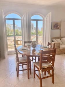 a dining room with a table and chairs and a couch at Vilamoura City Center Flat in Vilamoura