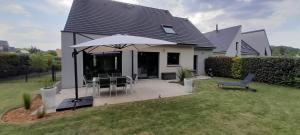 a house with an umbrella and a table and chairs at Chambre Privée proche circuit 24h, wi-fi , parking in Pruillé-le-Chétif