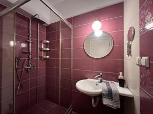 a purple bathroom with a sink and a mirror at Villa Perivoli in Parga