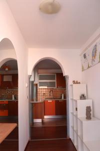 a kitchen with red cabinets and a white refrigerator at Nona Lili apartment in Izola