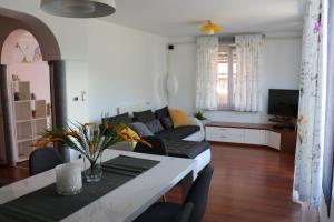 a living room with a couch and a table at Nona Lili apartment in Izola