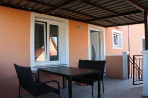 a table and chairs on a patio with a window at Nona Lili apartment in Izola