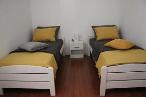 two twin beds in a room with a night stand at Nona Lili apartment in Izola