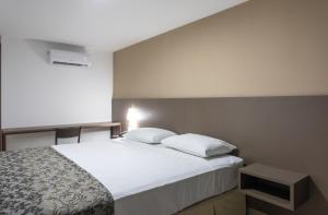 a bedroom with a white bed and a window at Hotel Annamar Premium in João Pessoa