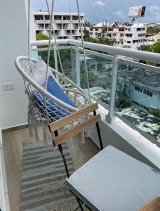 un porche con un columpio y una silla en un barco en Ambar 5D - Céntrico apart estilo Boho Chic en Santo Domingo