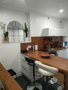 cocina con encimera de madera y mesa en Le Petit Cocon - Parking privé - Lyon Sud, en Vénissieux