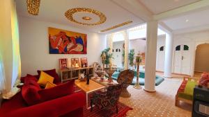 a living room with a red couch and a table at Art riad mazighen in El Jadida