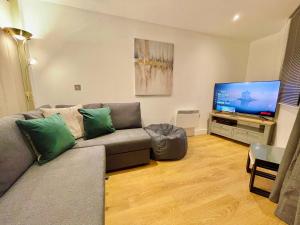a living room with a couch and a flat screen tv at Chic Leeds City Apartment, Free Parking, Balcony in Leeds