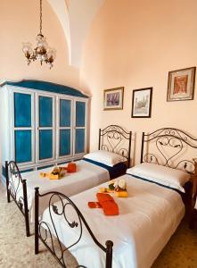two twin beds in a room with a chandelier at Casa Vacanza Zia Nunziatina in Copertino