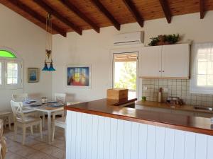 a kitchen and dining room with a table and a counter at Votsalo Summer House by the Beach in Porto Heli