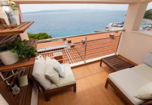 a balcony with a bench and a view of the ocean at Guesthouse Seaview in Brela