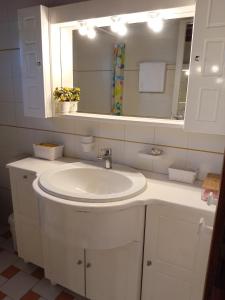 a bathroom with a white sink and a mirror at Votsalo Summer House by the Beach in Porto Heli +59 photos