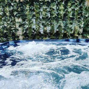 a hot tub filled with water next to a fence at Serendipity in Sutton on the Forest