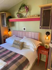 a bedroom with a large bed with a pink headboard at Serendipity in Sutton on the Forest