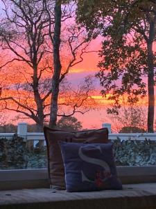 a pillow sitting in front of a window with a sunset at Serendipity in Sutton on the Forest +2 photos