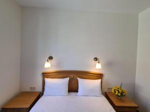 a bedroom with a bed with white sheets and lamps at Villa Loebel 1881 Annex Building in Juodkrantė