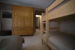 Bed & Bike Frasassi في Falcioni: غرفة نوم مع سريرين بطابقين وخزانة