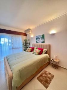 una camera da letto con un grande letto con cuscini rossi di Tavira Nature House a Tavira