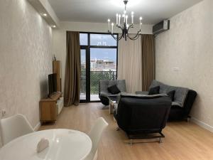 uma sala de estar com mesa e cadeiras e uma sala de jantar em Apartment D. Digomi em Tbilisi