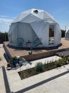 a tent with two chairs and a table in a garden at Maison du golf in Costinesti