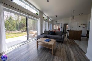 a living room with a couch and a table at Chalet le Geai bleu in Chertsey