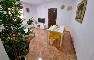 a living room with a table and a yellow chair at Apartamento Camino Al Castillo in Xàtiva