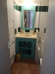 a bathroom with a blue sink and a mirror at Appartement 3 pièces, 6 perso avec piscine chauffée en saison domaine du golf de Pinsolle in Soustons