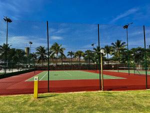 a tennis court with a net on a tennis court at Maresias, Chalé H29 em condomínio de frente a Entrada 18 da praia e dentro da Mata Atlântica in São Sebastião
