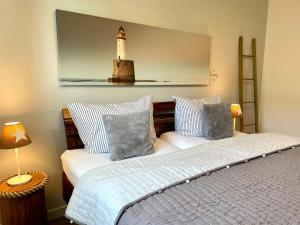 a bedroom with a bed and a lighthouse on the wall at Ferienwohnung Strandhafer - a64918 in Wittdün