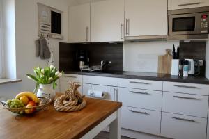 a kitchen with a wooden table with a bowl of fruit at Ferienwohnung Strandhafer - a64918 in Wittdün