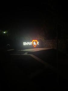un signe néon avec un cœur dans l'obscurité dans l'établissement Посуточный гостевой дом, à Gyumri