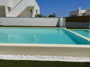 a blue swimming pool with rocks around it at Tuo Hotel in Polignano a Mare