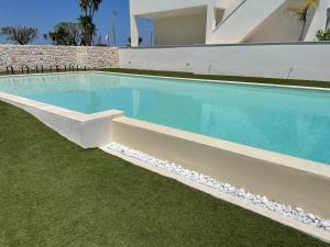 a swimming pool in a yard next to a building at Tuo Hotel in Polignano a Mare
