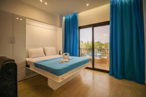 a bedroom with a bed with blue curtains and a balcony at SeaView Turtles in Hurghada