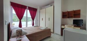 a bedroom with a bed and a large window at Alepou Guest House in Gasperina