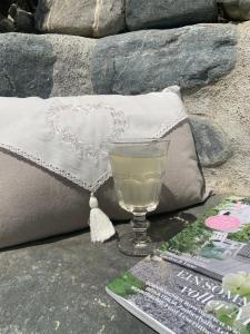 un bicchiere di vino seduto su un tavolo accanto ai cuscini di Chasa Tusa Scuol a Scuol
