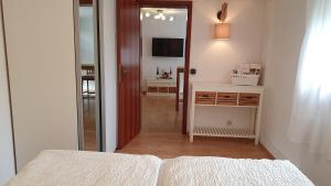 una camera con letto, specchio e TV di Ferienwohnung im Moseltal a Veldenz