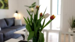 eine Vase mit Blumen auf einem Tisch im Wohnzimmer in der Unterkunft Lovely Hohen Neuendorf in Hohen Neuendorf