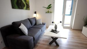 uma sala de estar com um sofá e uma mesa em Lovely Hohen Neuendorf em Hohen Neuendorf