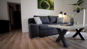 ein Wohnzimmer mit einem Sofa und einem Tisch in der Unterkunft Lovely Hohen Neuendorf in Hohen Neuendorf