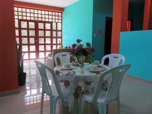 una mesa con sillas y un jarrón de flores. en Hospedaje Purma Wasi, en Tarapoto